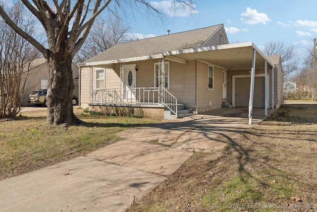 view of front of house featuring a garage, covered porch, a shingled roof, and concrete driveway