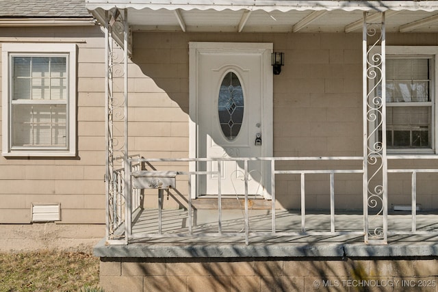 entrance to property featuring a shingled roof