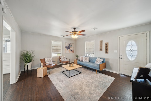 living room with ceiling fan, wood finished floors, visible vents, and baseboards