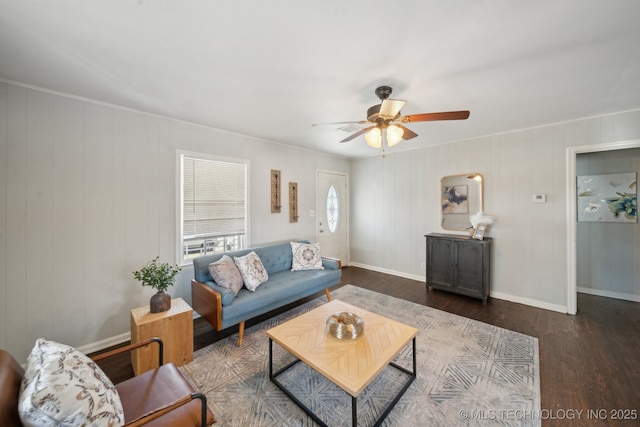 living room featuring a ceiling fan, baseboards, and wood finished floors