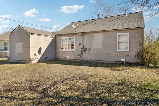 view of side of home featuring a yard, a shingled roof, and crawl space