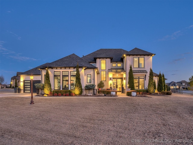 view of front of house featuring a garage, driveway, and stucco siding