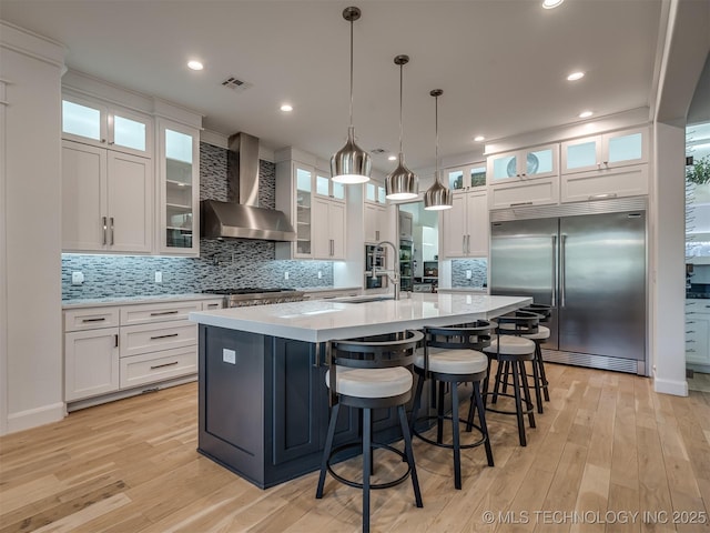 18420 E Persimmon Ln, Owasso, OK 74055 - kitchen with wall chimney range hood, stainless steel built in fridge, light countertops, a large island with sink, and decorative backsplash