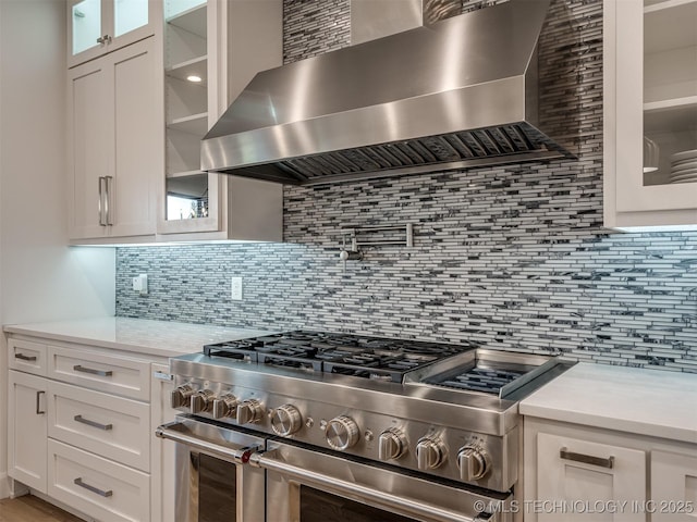 18420 E Persimmon Ln, Owasso, OK 74055 - kitchen with wall chimney range hood, range with two ovens, light countertops, and white cabinetry