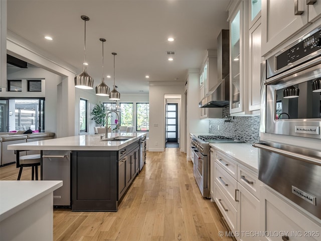 18420 E Persimmon Ln, Owasso, OK 74055 - kitchen with wall chimney exhaust hood, a warming drawer, high end range, white cabinets, and recessed lighting