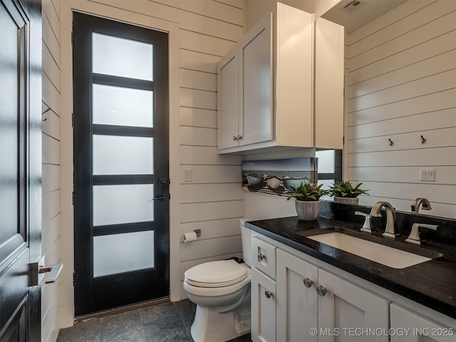 18420 E Persimmon Ln, Owasso, OK 74055 - bathroom with wood walls, vanity, and stone finish flooring