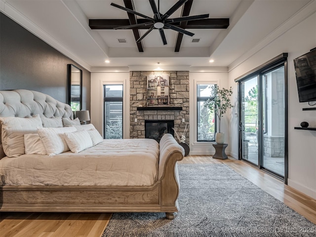 18420 E Persimmon Ln, Owasso, OK 74055 - bedroom with access to outside, wood finished floors, a stone fireplace, a raised ceiling, and beam ceiling