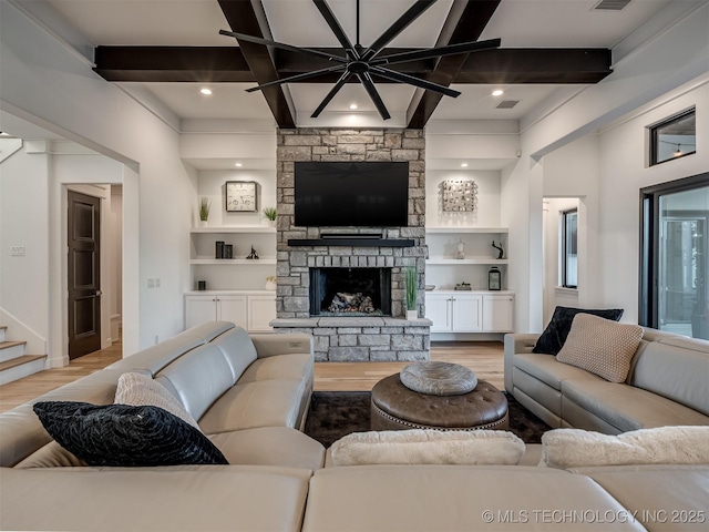 18420 E Persimmon Ln, Owasso, OK 74055 - living room featuring light wood finished floors, beam ceiling, a stone fireplace, built in shelves, and stairway