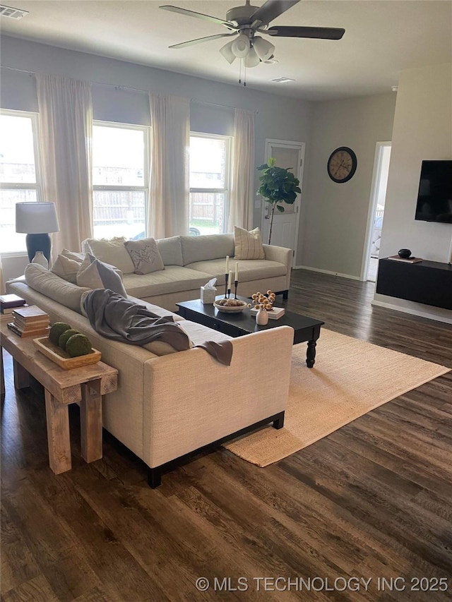 living room featuring ceiling fan, visible vents, and dark wood-style flooring