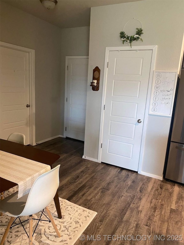 dining room with dark wood-style flooring and baseboards