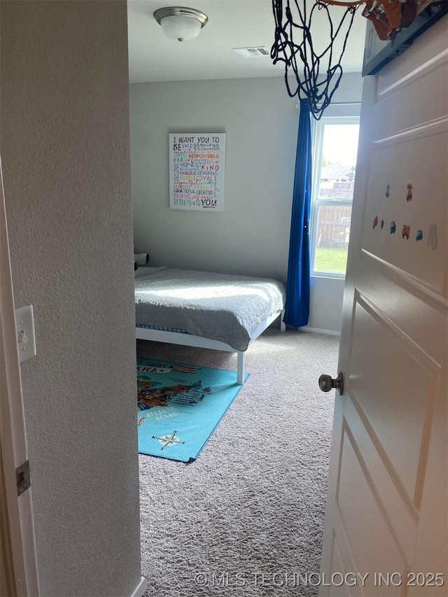 carpeted bedroom featuring visible vents