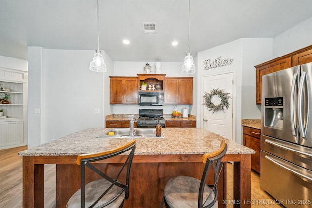 kitchen with black appliances, a center island with sink, open shelves, and decorative light fixtures