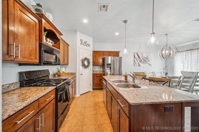 kitchen with a breakfast bar area, a sink, hanging light fixtures, black appliances, and a center island with sink