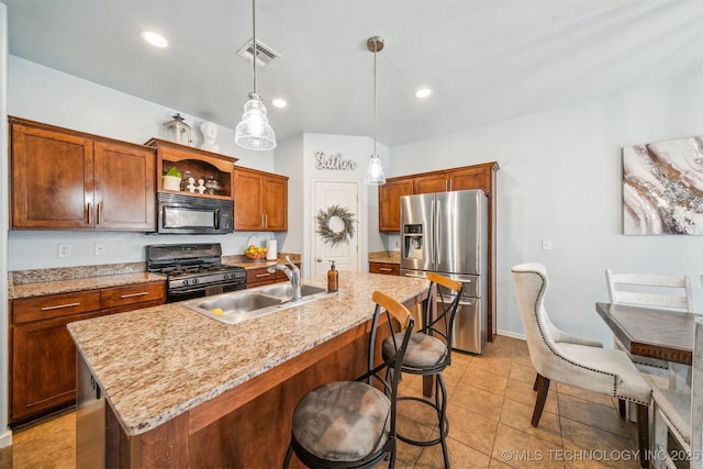 kitchen with decorative light fixtures, a sink, an island with sink, and black appliances