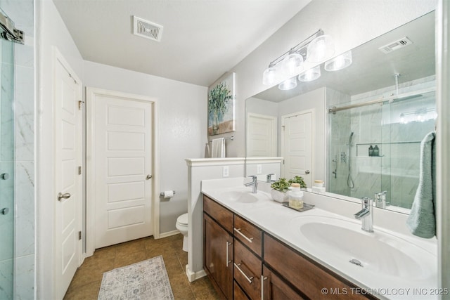 bathroom featuring a stall shower, visible vents, and a sink