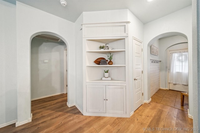 hall featuring baseboards and wood finished floors