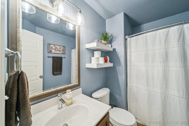 bathroom with toilet, a shower with shower curtain, and vanity