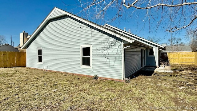 view of side of property featuring a lawn and a fenced backyard