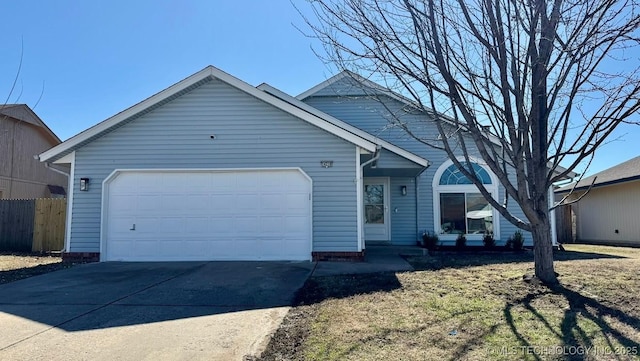 single story home featuring a garage, driveway, and fence