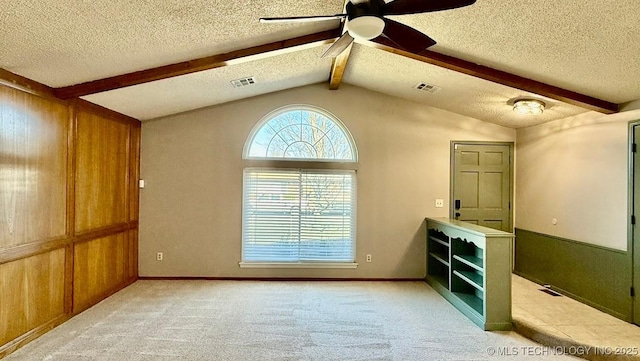 unfurnished room featuring light carpet, ceiling fan, visible vents, and vaulted ceiling with beams