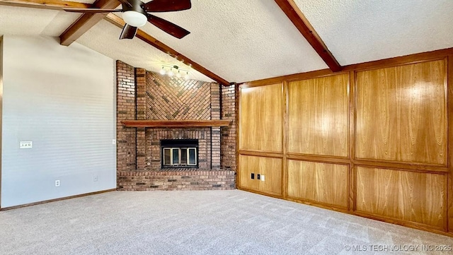 unfurnished living room featuring a textured ceiling, vaulted ceiling with beams, a ceiling fan, a brick fireplace, and carpet