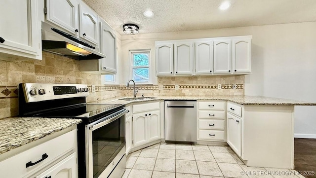 kitchen featuring white cabinets, appliances with stainless steel finishes, a peninsula, under cabinet range hood, and a sink