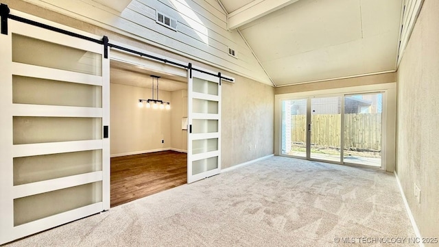 carpeted spare room featuring vaulted ceiling with beams, a barn door, built in shelves, visible vents, and baseboards