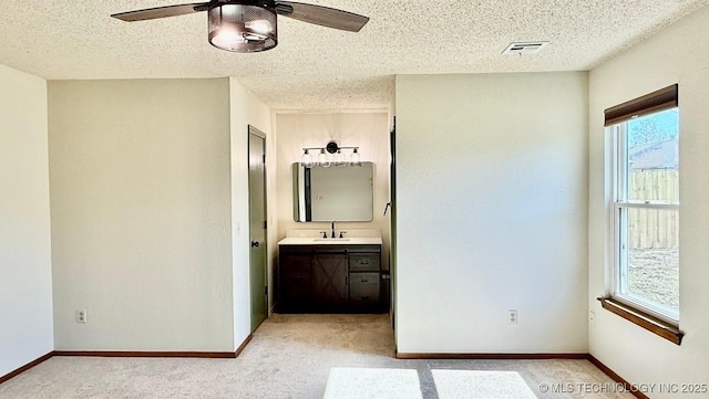 unfurnished bedroom with light carpet, a textured ceiling, visible vents, and baseboards