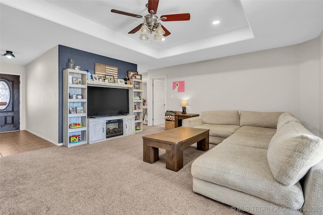 carpeted living area featuring baseboards, a raised ceiling, a ceiling fan, and recessed lighting