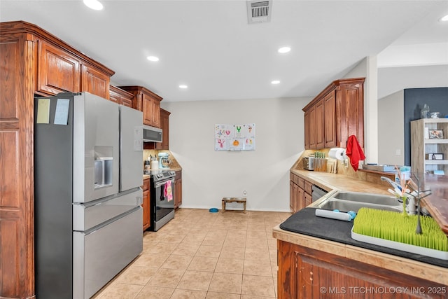 kitchen with stainless steel appliances, recessed lighting, light countertops, light tile patterned flooring, and a sink