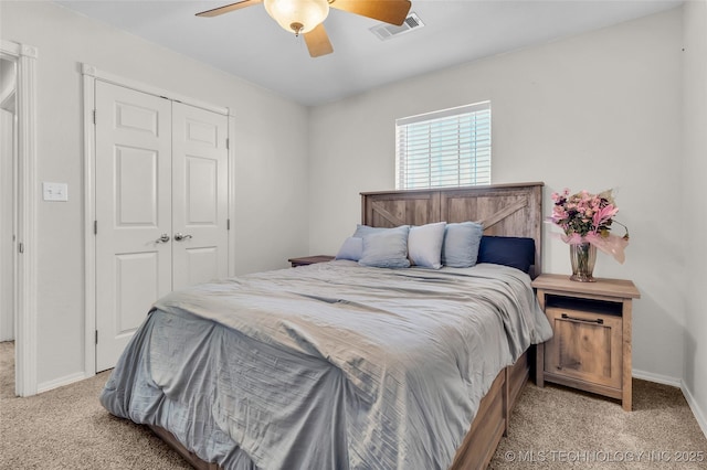 bedroom featuring a closet, visible vents, light carpet, ceiling fan, and baseboards