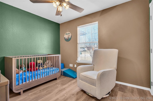 bedroom featuring wood finished floors, a ceiling fan, and baseboards