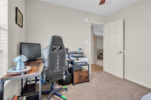 office space with carpet, a ceiling fan, and baseboards