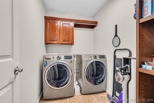 washroom featuring cabinet space, light tile patterned flooring, baseboards, and independent washer and dryer