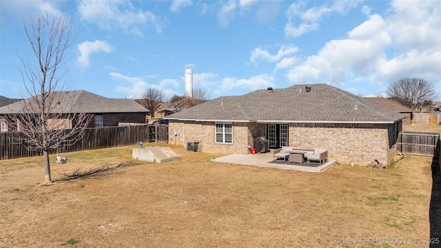 back of property with brick siding, a lawn, a patio area, and a fenced backyard