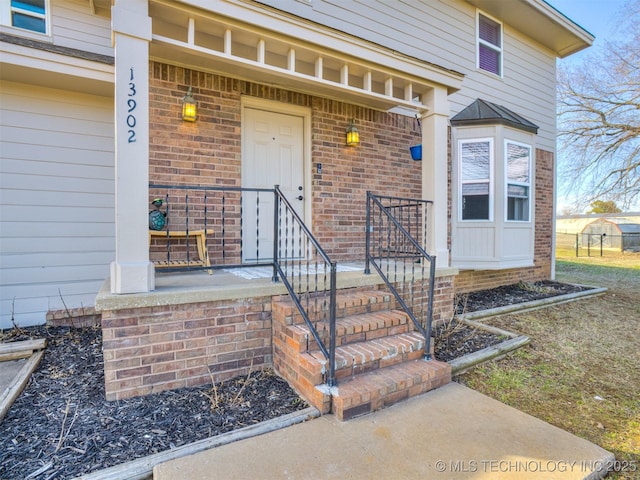 view of exterior entry featuring brick siding