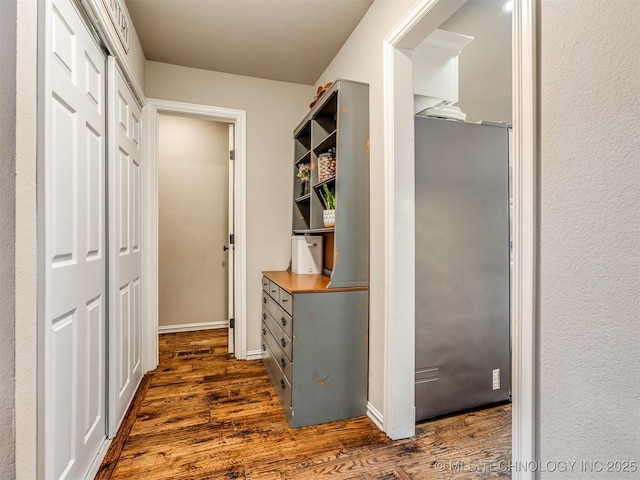 corridor with baseboards and dark wood-type flooring