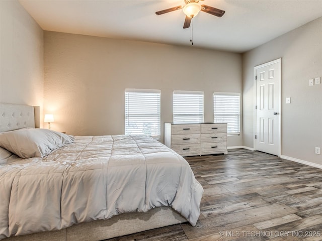 bedroom with dark wood-style floors, baseboards, and a ceiling fan