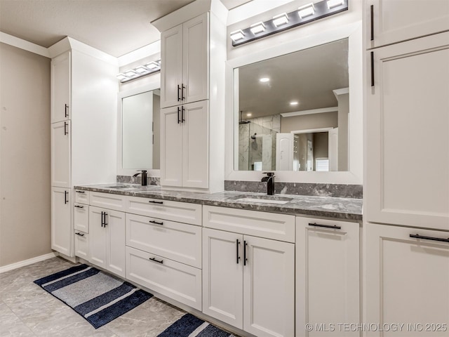 full bathroom with a sink, a shower stall, baseboards, and double vanity