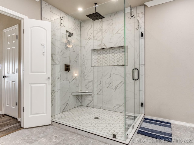 full bath featuring a shower stall and baseboards