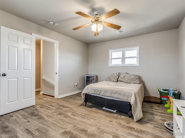 bedroom with light wood-style flooring, visible vents, ceiling fan, and baseboards