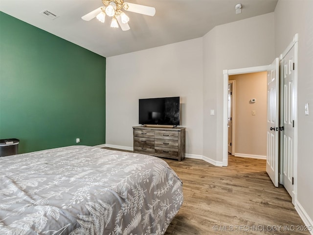 bedroom with light wood-type flooring, baseboards, visible vents, and a ceiling fan