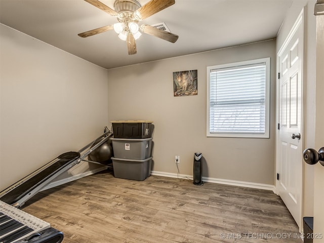 interior space with ceiling fan, visible vents, baseboards, and wood finished floors