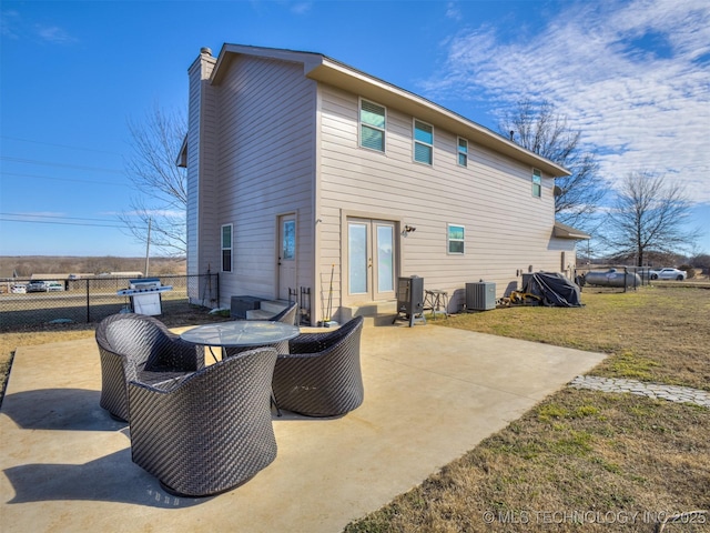 back of house featuring a lawn, a patio, a chimney, fence, and central air condition unit