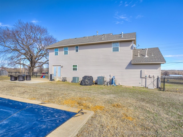 rear view of property featuring a patio area, fence, a lawn, and central air condition unit