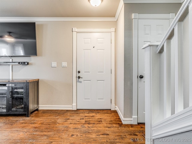 foyer with ornamental molding, wine cooler, baseboards, and wood finished floors