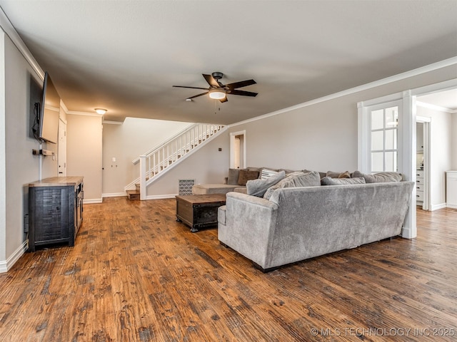 living area featuring ornamental molding, dark wood-type flooring, stairway, and baseboards