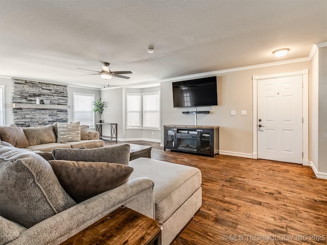 13902 S 241st E Ave, Coweta, OK 74429 - living area with a stone fireplace, ornamental molding, a ceiling fan, wood finished floors, and baseboards