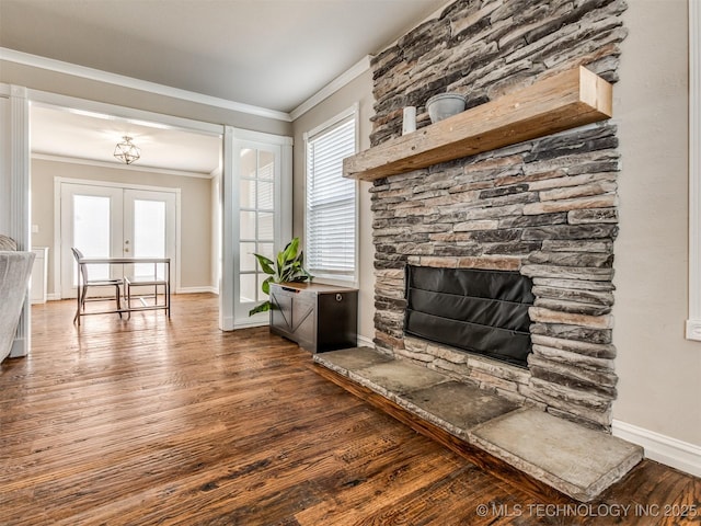 living room featuring ornamental molding, a stone fireplace, french doors, and wood finished floors