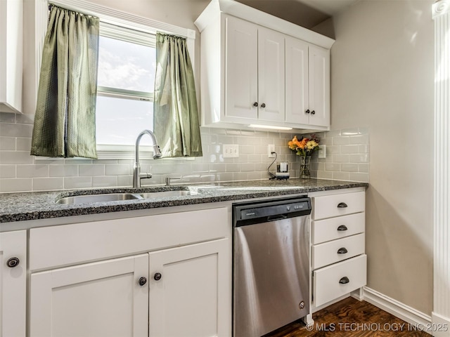 kitchen with dishwasher, tasteful backsplash, a sink, and white cabinetry